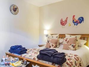 a bedroom with a bed with chickens on the wall at Stunning cottage nestled under the Longmynd Hills. in Church Stretton