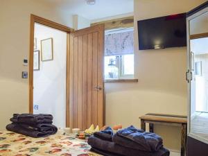 a room with a bed with clothes on it at Stunning cottage nestled under the Longmynd Hills. in Church Stretton