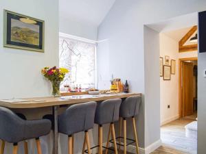 a kitchen with a counter with chairs around it at Stunning cottage nestled under the Longmynd Hills. in Church Stretton
