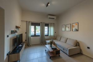 a living room with a couch and a tv at Galio Suites Airport by Airstay in Spata