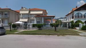 a large house with a fence in front of it at Seaview Apartment & semi basement seaview Apartment in Nea Vrasna