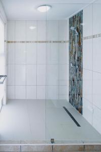La salle de bains est pourvue d'une douche avec une porte en verre. dans l'établissement Het paradijs in Jan Thiel!, à Jan Thiel