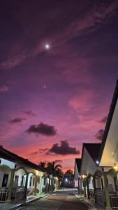 a night view of a street with a purple sky at The Nutshell Chalet Langkawi in Pantai Cenang