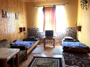 Zimmer mit 2 Betten und einem TV. in der Unterkunft Mazury - Domki letniskowe u Teresy in Wydminy