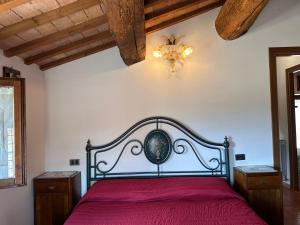 a bedroom with a red bed and a chandelier at G&G Casa Vacanze in Deruta