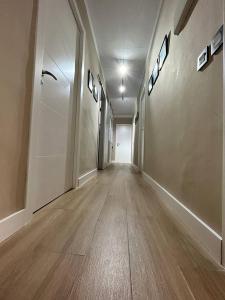 an empty hallway with a long corridor with wood floors at El corazon de la Luna in Badajoz