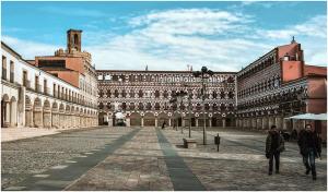 a large building with two people walking in front of it at El corazon de la Luna in Badajoz
