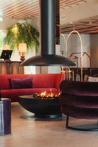 a fire pit in the middle of a living room with a couch at Ad Astra by Elite - Hotel, Spa & Resort in Södertälje