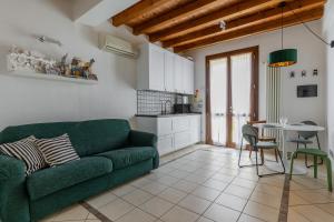 ein Wohnzimmer mit einem grünen Sofa und einem Tisch in der Unterkunft Osvaldo - parcheggio e giardino privato in San Giovanni in Persiceto