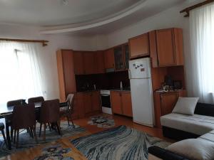 a kitchen with a table and a white refrigerator at Nino's apartment-Isolated floor for rent in Tbilisi City