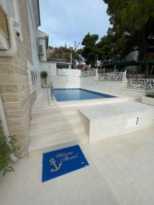 a sign for a swimming pool next to a house at Casa del Mare in Rogoznica