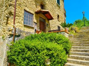 ein Steingebäude mit einer Treppe, die zu einer Tür führt in der Unterkunft Cilento Stone House in San Mauro Cilento