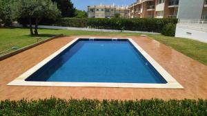a large swimming pool on top of a patio at 3 Bedroom Apartment with pool Alvor in Alvor