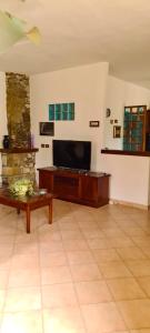 ein Wohnzimmer mit einem Flachbild-TV und einem Kamin in der Unterkunft Cilento Stone House in San Mauro Cilento