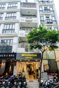 a tall white building with motorcycles parked in front of it at Wild Lotus Hotel & Travel 2 in Hanoi