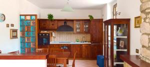 eine Küche mit Holzschränken sowie einem Tisch und Stühlen in der Unterkunft Cilento Stone House in San Mauro Cilento