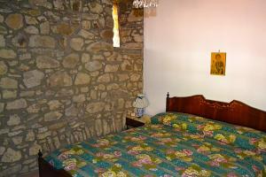 ein Schlafzimmer mit einem Bett und einer Steinmauer in der Unterkunft Cilento Stone House in San Mauro Cilento
