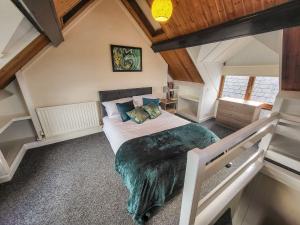 a bedroom with a large bed in a attic at Cosy seaside town cottage with private garden in Cardigan