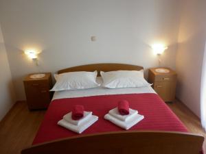 a bedroom with a bed with two hats on it at Apartments Ivona 2 in Trogir