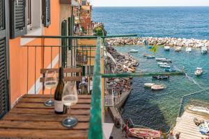 a balcony with a view of a body of water with boats at EC Luxury Rooms in Riomaggiore