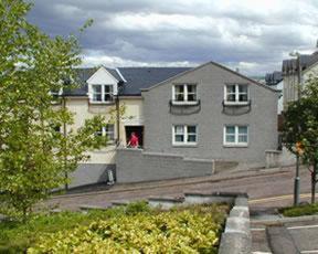 a person standing in the doorway of a house at Bank Street Lodge in Fort William