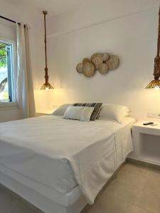 a bedroom with a large white bed with white sheets at Anixis Studios Aliki Paros in Aliki