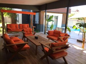 a patio with orange chairs and a wooden table at BEGONVİL VİLLA in Belek