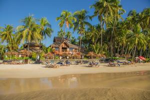 - une plage avec des chaises longues et des palmiers ainsi qu'un complexe dans l'établissement Yoma Cherry Lodge, à Ngapali Beach