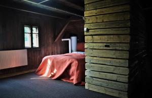 1 dormitorio con 1 cama en una habitación de madera en Chata nad Dziką Orlicą z jacuzzi, 