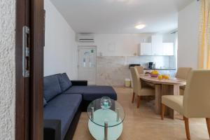 sala de estar con sofá azul y mesa en A3 - seafront apt with balcony 1 min to beach en Trogir