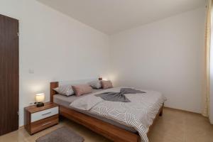 1 dormitorio con cama y pared blanca en A3 - seafront apt with balcony 1 min to beach en Trogir