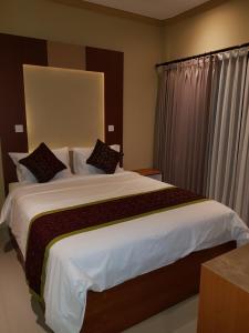 1 dormitorio con 1 cama grande con sábanas y almohadas blancas en Villager's House Ubud en Gianyar