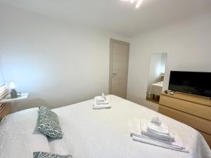 1 dormitorio con 1 cama, TV y toallas en A Cà Mea, en La Spezia