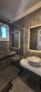 a bathroom with a sink and a glass shower at Paros Blue Dolphin FULLY RENOVATED by RIVEA GROUP in Chrissi Akti