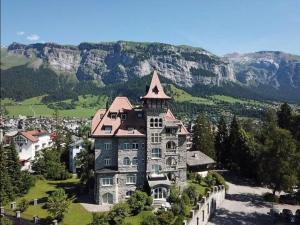 uma casa grande no topo de uma montanha em Edelweiss Schlosswohnung em Flims