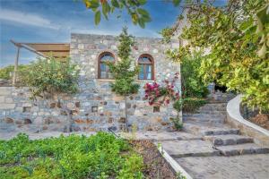 a stone house with stairs in front of it at Villa Margarita Studio in Patmos