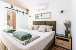Un dormitorio con una cama con sábanas y almohadas blancas. en Šolta Stone House, en Stomorska 34 fotos más