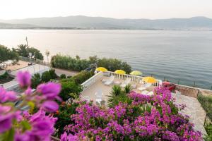 una vista del agua con flores y sombrillas púrpuras en Villa Fjaba - by the sea - with the big terraces & great sea view, en Trogir