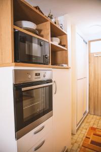 La cocina está equipada con microondas y horno. en Sončni apartma, en Bovec