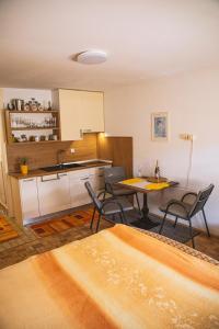 cocina y comedor con mesa y sillas en Sončni apartma, en Bovec