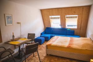 a bedroom with a bed and a couch and a table at Sončni apartma in Bovec