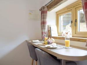 a kitchen with a table with a glass of orange juice at Cosy and quiet one bed barn conversion. in Church Stretton