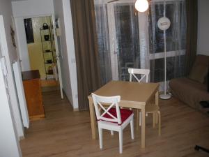 einen Esstisch und Stühle im Wohnzimmer in der Unterkunft Les Bastides in Gréoux-les-Bains