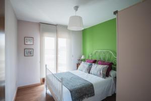 um quarto com uma parede verde e uma cama em Chalet Os castaños em Caldas de Reis