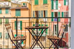 twee stoelen en een fles wijn op een tafel op een balkon bij EC Luxury Rooms in Riomaggiore