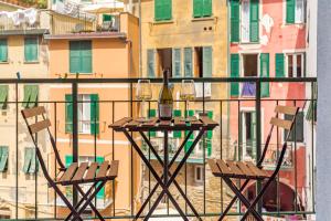 2 Stühle und eine Flasche Wein auf dem Tisch auf dem Balkon in der Unterkunft EC Luxury Rooms in Riomaggiore