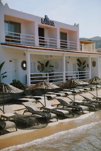 una fila de sombrillas en la playa frente a un hotel en Lavinya Otel, en Golturkbuku