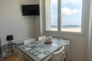 a dining room table with a view of the ocean at Le Kador, appartement avec vue sur mer in Crozon