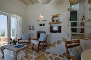 Una sala de estar con una mesa y sillas y un televisor. en Villa Elliah, en Episkopianá