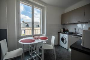 una cocina con una mesa pequeña y una ventana en Le Kador, appartement avec vue sur mer, en Crozon